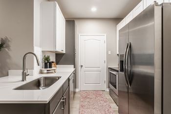 a kitchen with stainless steel appliances and a sink at Alexandria of Carmel Apartments, Carmel